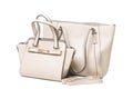 Two light beige women`s bags on a white background, one bag more than another