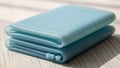 Two light blue silicone foldable containers are stacked on a light wood surface. The material is Royalty Free Stock Photo
