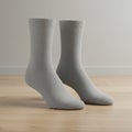 Two light gray socks are displayed standing upright, seemingly unsupported, on a Royalty Free Stock Photo
