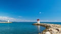 Two lighthouses at the entrance to the Bay of the French Riviera on a clear Sunny day against a blue sky with clouds