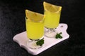 Two limoncellos and mint branches on a black background. Royalty Free Stock Photo