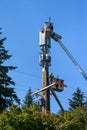 Two linemen working on a wireless communications radio and antenna installation using a bucket truck Royalty Free Stock Photo