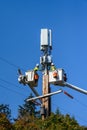 Two linemen working on a wireless communications radio and antenna installation using a bucket truck Royalty Free Stock Photo