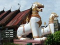 Two lions guarding the entrance to a temple in Thailand