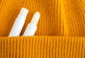 Two lip balms on the orange knitted background. Winter lip care sticks with beeswax, honey, panthenol and shea butter. Copy space.