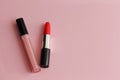 Red lipstick and liquid pink lipstick on a pink background Royalty Free Stock Photo