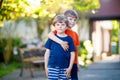 Two little active school kids boys, twins and siblings hugging on summer day Royalty Free Stock Photo