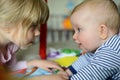 Two little adorable Caucasian sisters look at each other. They are happy and smiling.