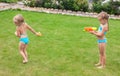 Two little adorable girls playing with water guns Royalty Free Stock Photo