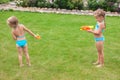 Two little adorable girls playing with water guns Royalty Free Stock Photo