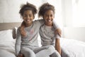 Two little african american girls on bed at home