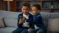 Two little African American siblings boys children kids little brothers with mobile phone smartphone playing game online Royalty Free Stock Photo