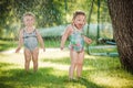 The two little baby girls playing with garden sprinkler. Royalty Free Stock Photo