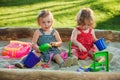 The two little baby girls playing toys in sand Royalty Free Stock Photo