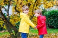 Two little best friends and kids boys autumn park in colorful clothes. Happy siblings children having fun in red and Royalty Free Stock Photo