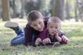 Two little blond brothers laying in grass in the spring Royalty Free Stock Photo