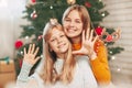 Two little blond sisters of European appearance are looking at the frame and waving their hand, communicating via a Royalty Free Stock Photo