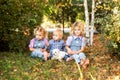 Two little blonde girls and baby boy playing in the garden with cute white puppy Royalty Free Stock Photo