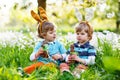 Two little boy friends in Easter bunny ears eating chocolate Royalty Free Stock Photo