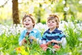 Two little boy friends in Easter bunny ears eating chocolate Royalty Free Stock Photo