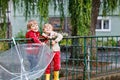 Two little boys, best friends and siblings walking with big umbrella outdoors on rainy day. Preschool children having Royalty Free Stock Photo