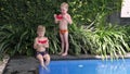 Two little boys eat watermelon on vacation by the poolside. boys eat watermelon in the summer in the yard