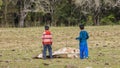 Two little boys in front of a dead cow.
