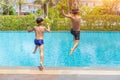 Two little boys fun jumping into the swimming pool, Summer holidays and vacation concept Royalty Free Stock Photo