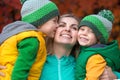 Two little boys gently hug and kiss your beloved mother.A walk in the autumn woods.