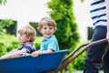 Two little boys having fun in a wheelbarrow