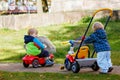 two little boys playing with cars and bikes outdoors. Happy children siblings in autumn park. Toddlers twins wears Royalty Free Stock Photo