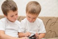 Two little boys playing games on smartphone Royalty Free Stock Photo