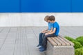 Two little boys playing with mobile phone sitting on the bench outdoors Royalty Free Stock Photo