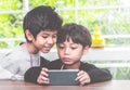 Two boys are playing online game on mobile phone Royalty Free Stock Photo