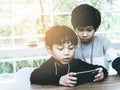 Two Little boys playing online game on mobile phone Royalty Free Stock Photo