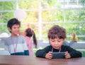 Two Little boys playing online game on mobile phone Royalty Free Stock Photo