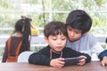 Two Little boys playing online game on mobile phone Royalty Free Stock Photo