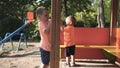 Two little boys playing on the playground with swing on the background
