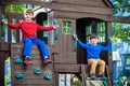 Two little boys playing together and having fun. Lifestyle family moment of siblings on playground. Kids friends play on tree Royalty Free Stock Photo