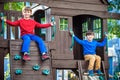 Two little boys playing together and having fun. Lifestyle family moment of siblings on playground. Kids friends play on tree Royalty Free Stock Photo