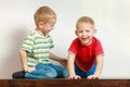 Two little boys siblings playing together on table