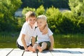 Two little boys sit in an embrace on the banks of the river. Concept of friendship and fraternity Royalty Free Stock Photo