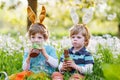 Two little boys wearing Easter bunny ears and eating chocolate Royalty Free Stock Photo