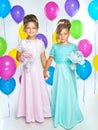 Two little bridesmaids with bouquets in long dresses