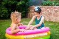 Two little brother and sister playing and splashing in pool on hot summer day. Children swimming in kid pool. Two cheerful cute Royalty Free Stock Photo