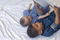 Two little brothers reading a book. Infant kids lying on the bed and read the tale before sleeping. Reading a short story for Kids Royalty Free Stock Photo