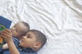 Two little brothers reading a book. Infant kids lying on the bed and read the tale before sleeping. Reading a short story for Kids Royalty Free Stock Photo