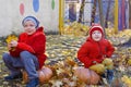 Two little brothers sitting on pumpkin outdoors in autumn. Helloween. Royalty Free Stock Photo