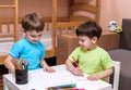 Two little caucasian friends playing with lots of colorful plastic blocks indoor. Active kid boys, siblings having fun building an Royalty Free Stock Photo