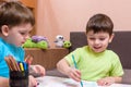 Two little caucasian friends playing with lots of colorful plastic blocks indoor. Active kid boys, siblings having fun building an Royalty Free Stock Photo